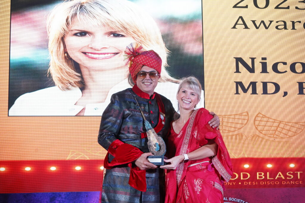 Dr. Nicole Rogers accepting the Golden Follicle Award from Dr. Kapil Dua